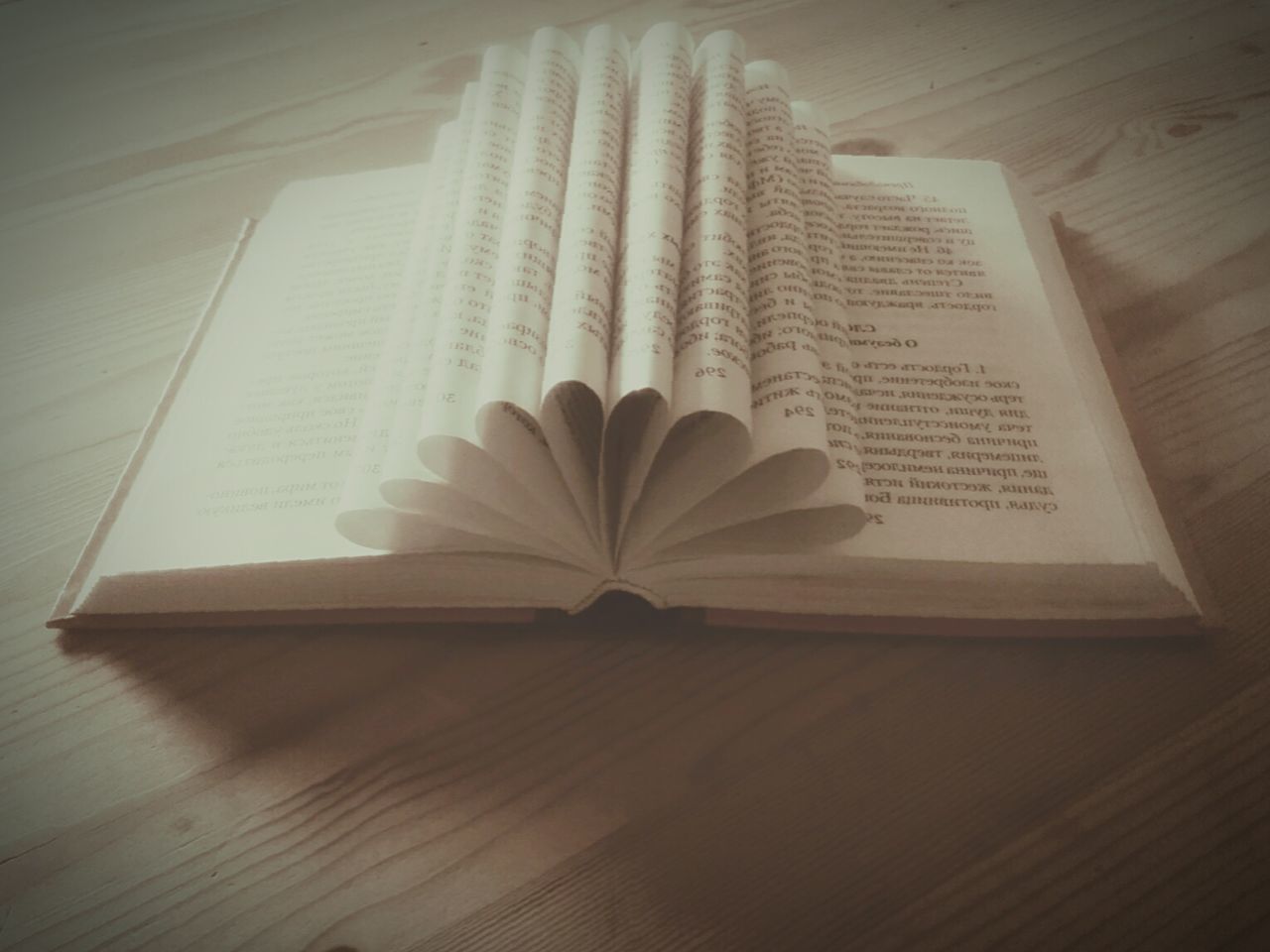 CLOSE-UP OF OPEN BOOK ON TABLE