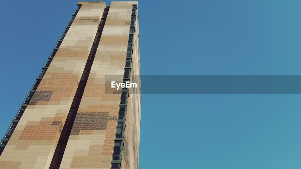 Low angle view of skyscraper against clear blue sky