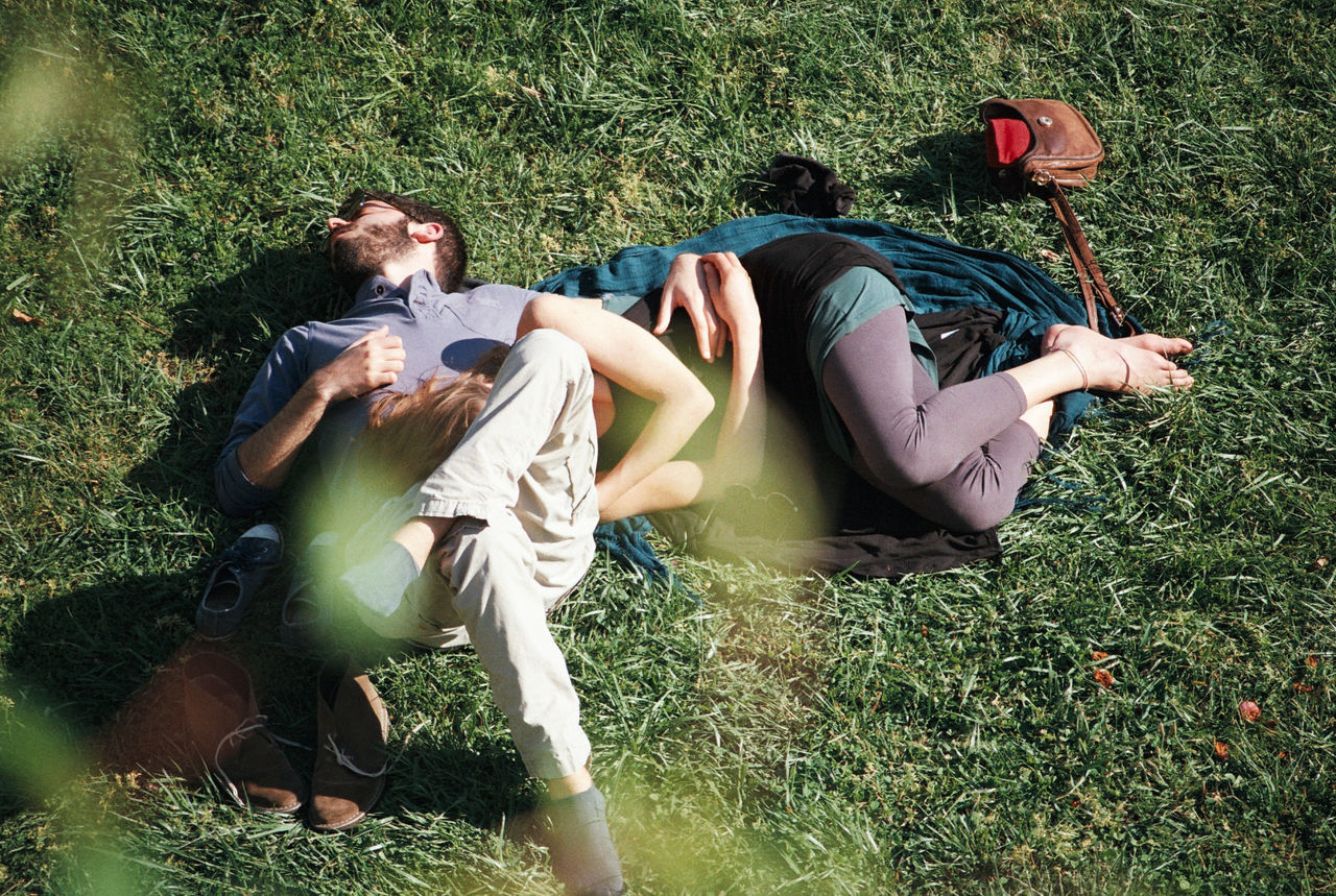 YOUNG COUPLE LYING IN GRASS