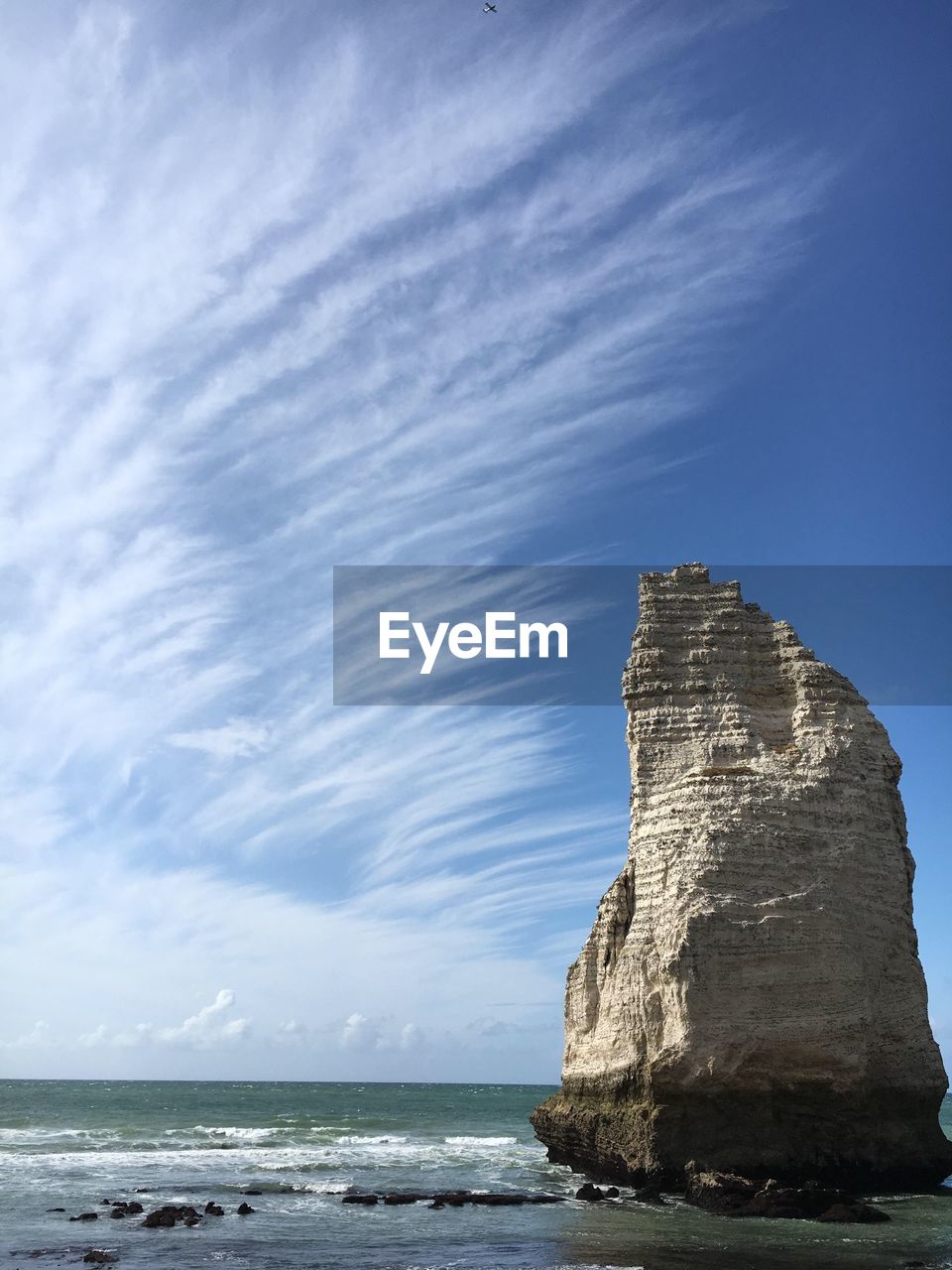 Rock formation on beach against sky