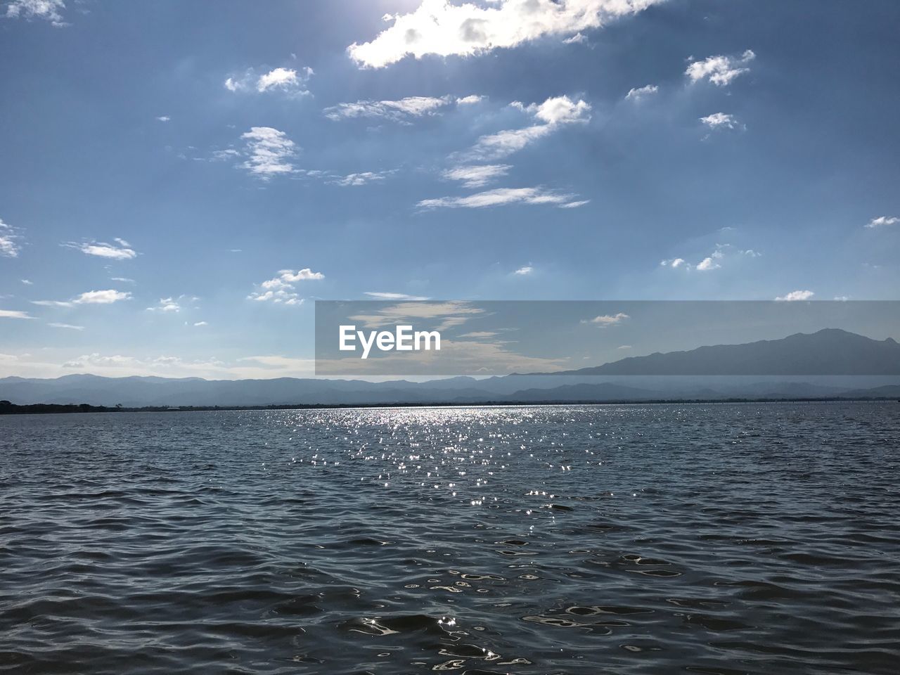 SCENIC VIEW OF SEA AGAINST MOUNTAINS