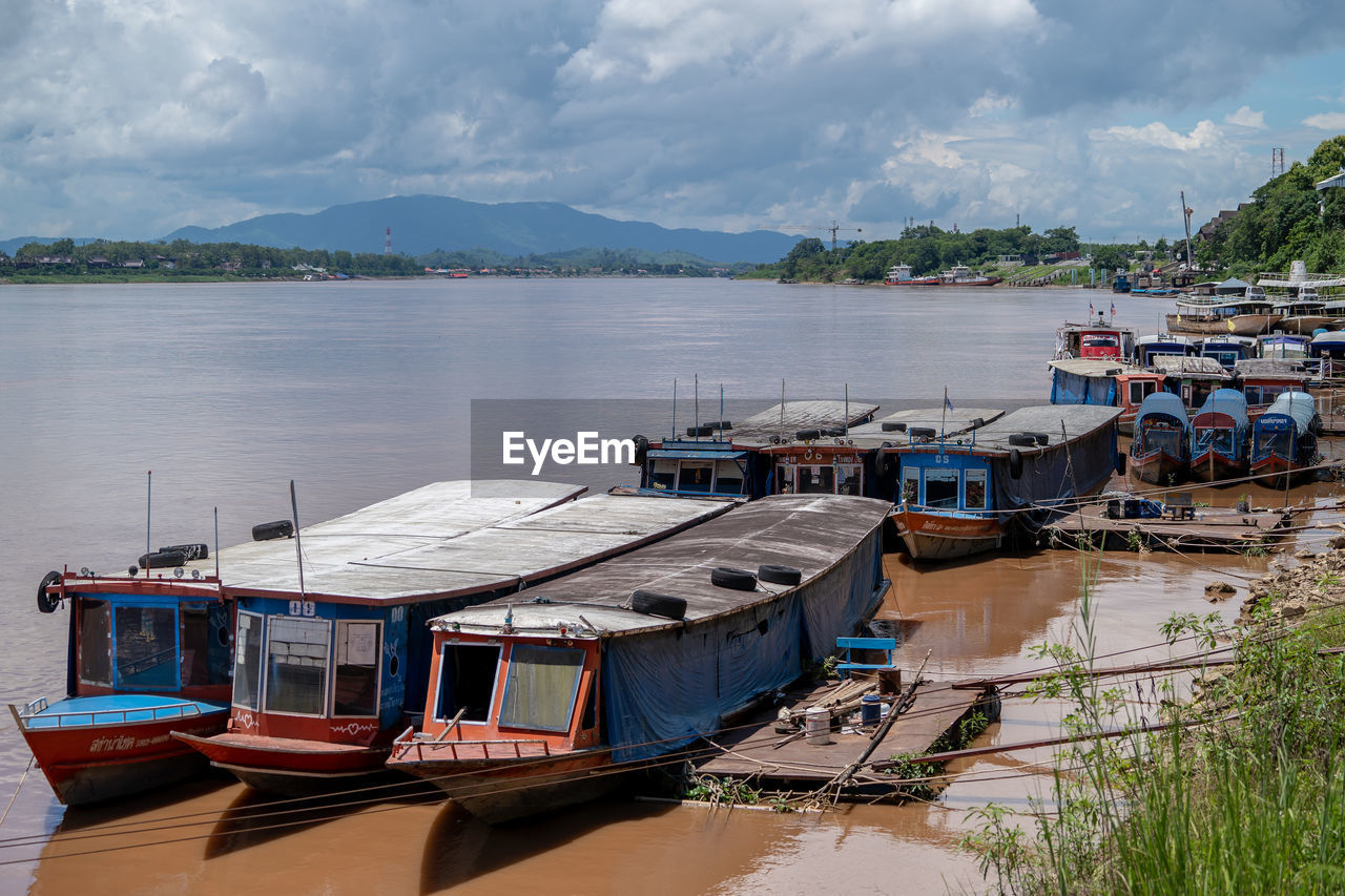 water, nautical vessel, transportation, sea, nature, mode of transportation, sky, architecture, cloud, beach, travel, travel destinations, land, moored, vehicle, boat, harbor, landscape, tranquility, environment, tourism, ship, scenics - nature, beauty in nature, bay, vacation, no people, holiday, mountain, pier, trip, building, built structure, coast, building exterior, day, outdoors, tranquil scene, waterway, reflection, house, watercraft, coastline, city, village, dock, fishing, body of water, idyllic, water's edge, fishing industry, plant, bay of water, ferry, recreational boat, tradition, wood