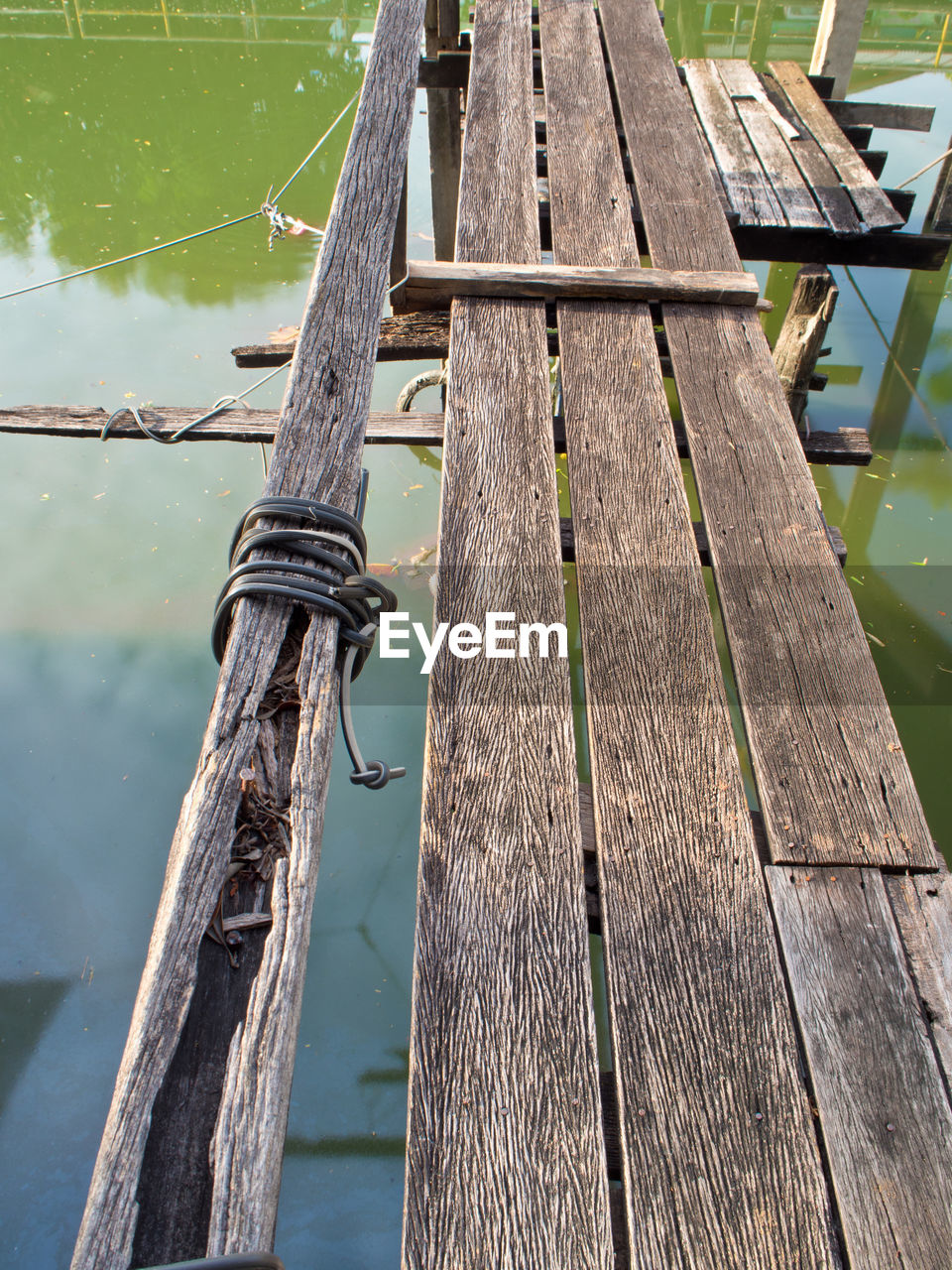 CLOSE-UP OF WOODEN POST IN LAKE