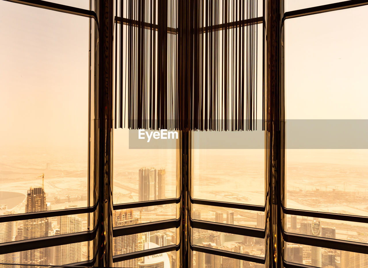 CLOSE-UP OF GLASS WINDOW AGAINST SKY