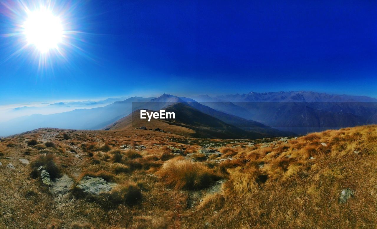 Scenic view of mountains against blue sky