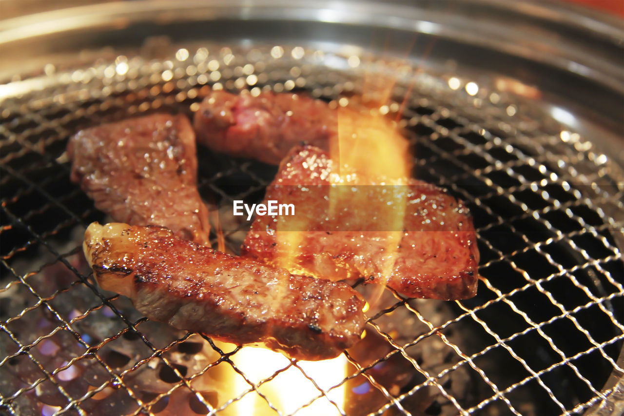 CLOSE-UP OF MEAT ON GRILL