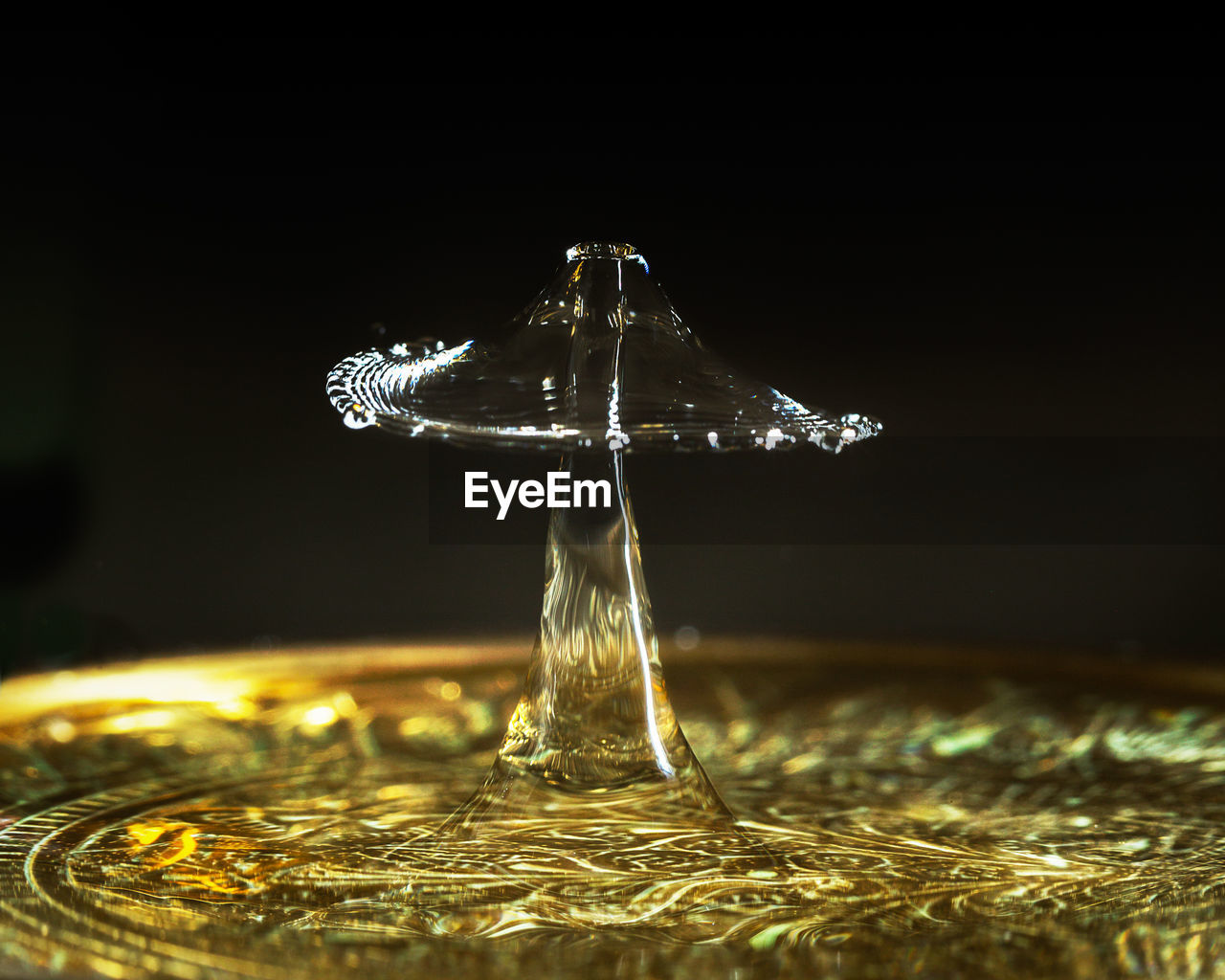 CLOSE-UP OF WATER SPLASHING ON GLASS TABLE