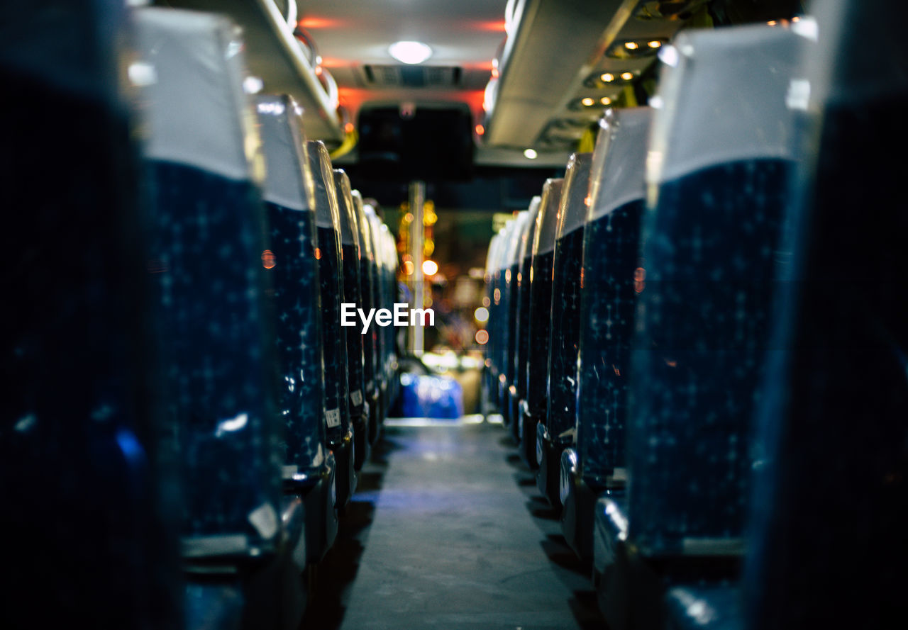 Empty seats in illuminated bus at night