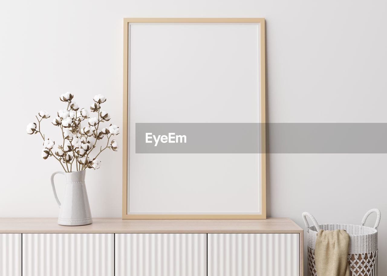 Empty vertical picture frame on white wall in modern living room. mock up interior 