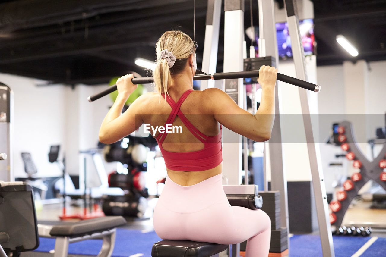 A back view of a woman working out in the gym.