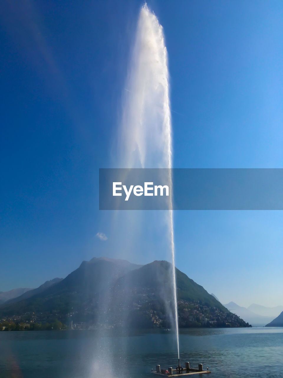 Water splashing on mountain against sky