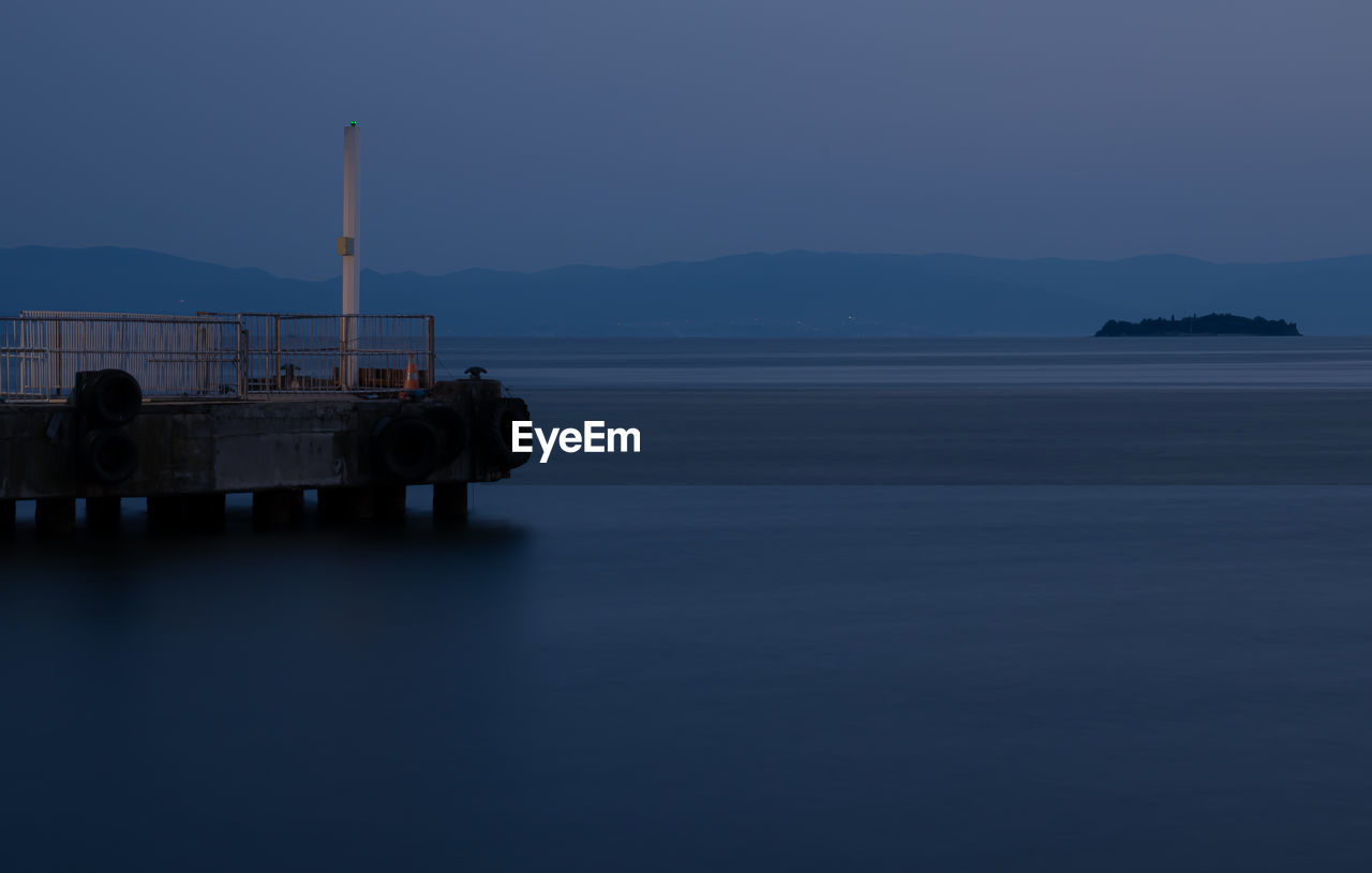 Scenic view of sea against clear sky at dusk