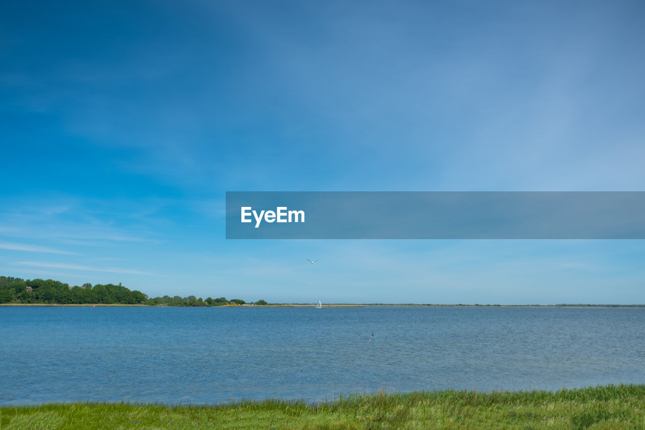 Scenic view of sea against blue sky