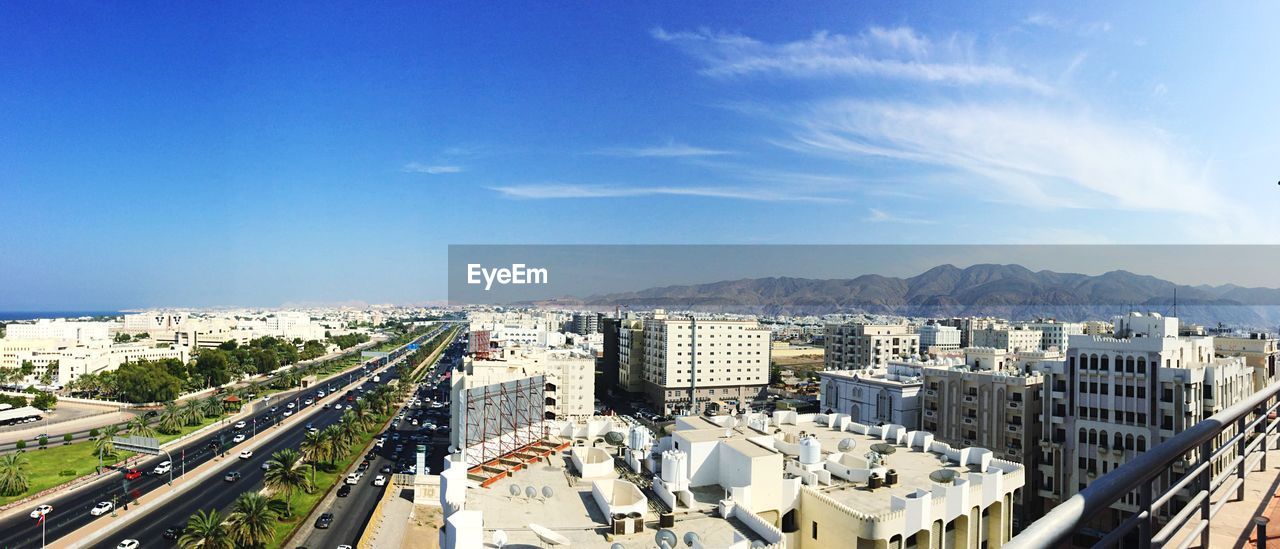 High angle view of buildings in city against blue sky