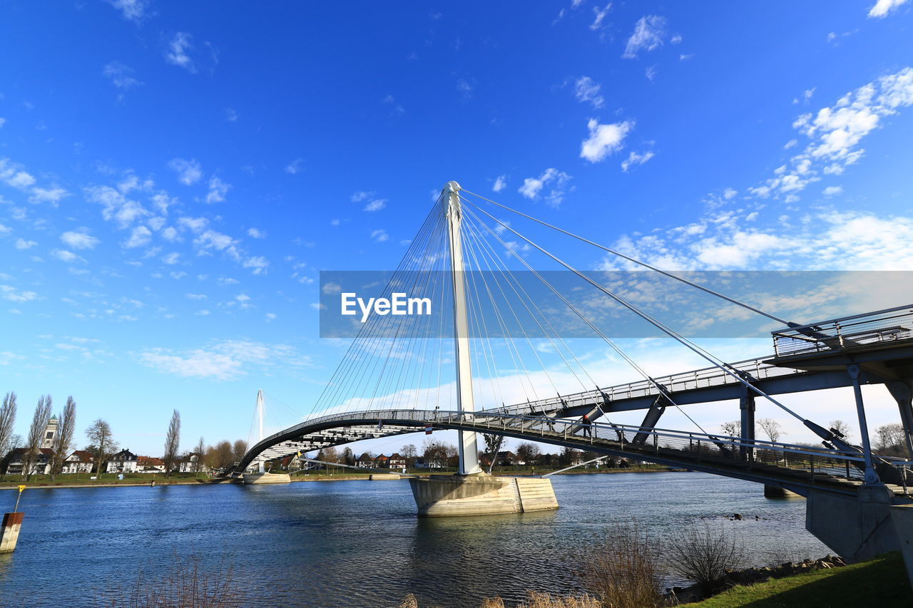 LOW ANGLE VIEW OF SUSPENSION BRIDGE AGAINST BLUE SKY