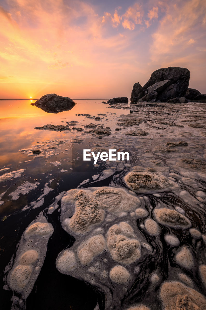 SCENIC VIEW OF ROCKS AT BEACH AGAINST SKY