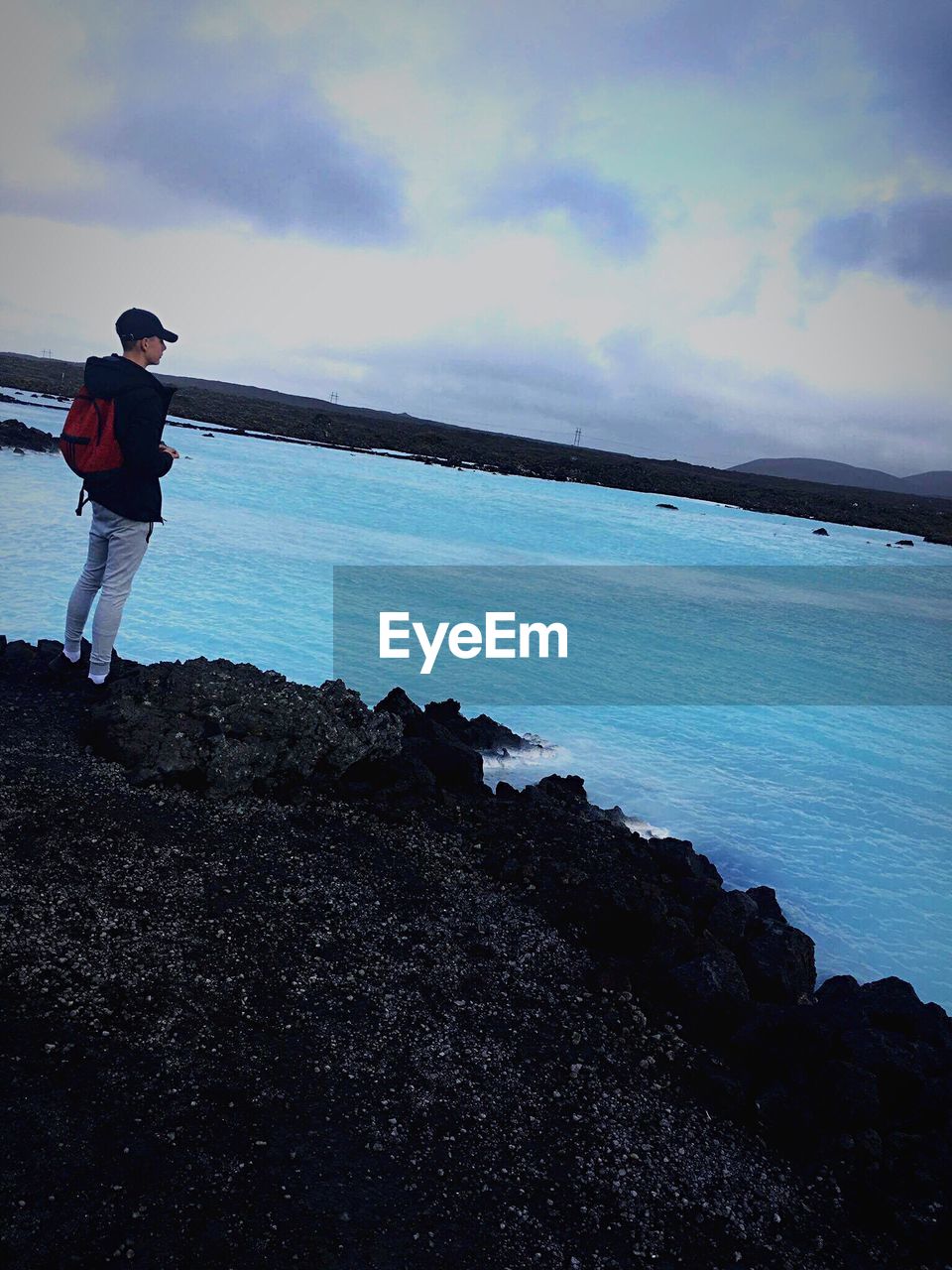 FULL LENGTH OF MAN STANDING ON SEA AGAINST SKY