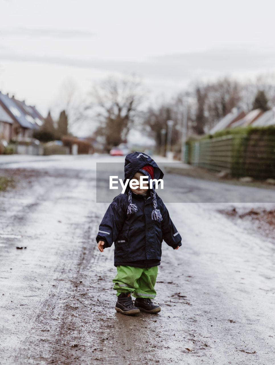 Full length of cute baby standing on wet road