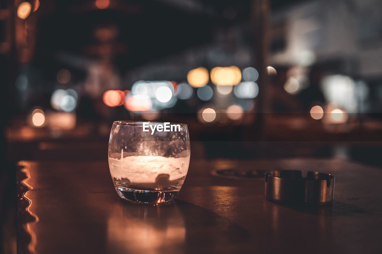 CLOSE-UP OF BEER GLASS ON TABLE