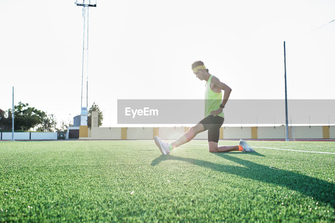 Young boy in sportswear practices stretching after running training