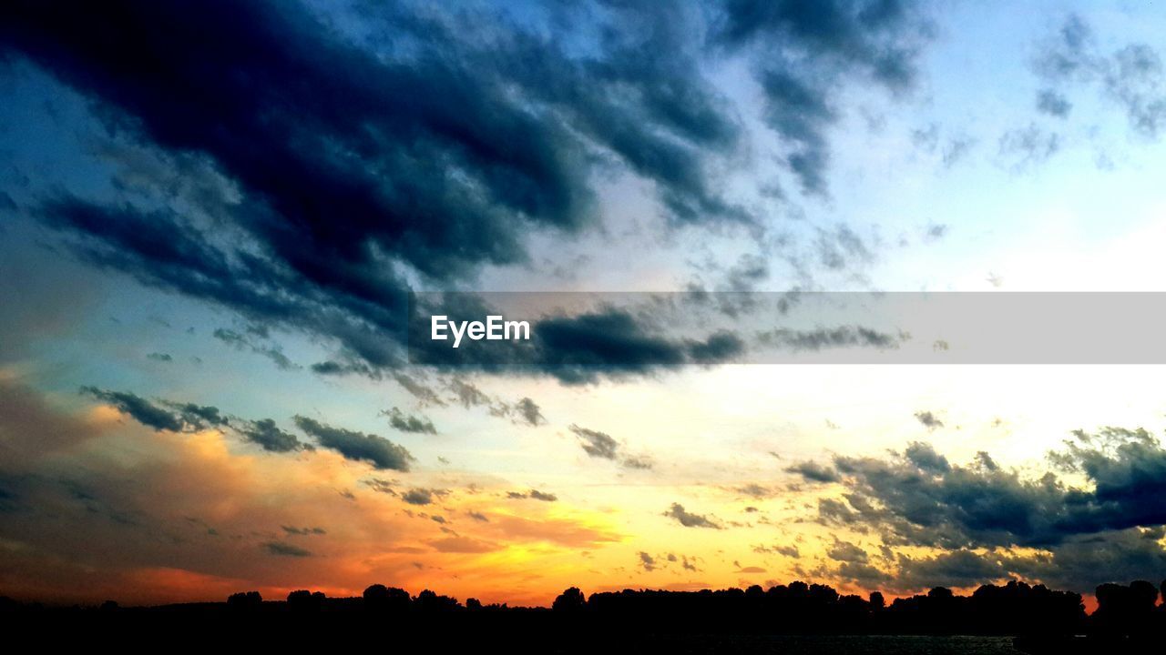 LOW ANGLE VIEW OF DRAMATIC SKY OVER SILHOUETTE LANDSCAPE