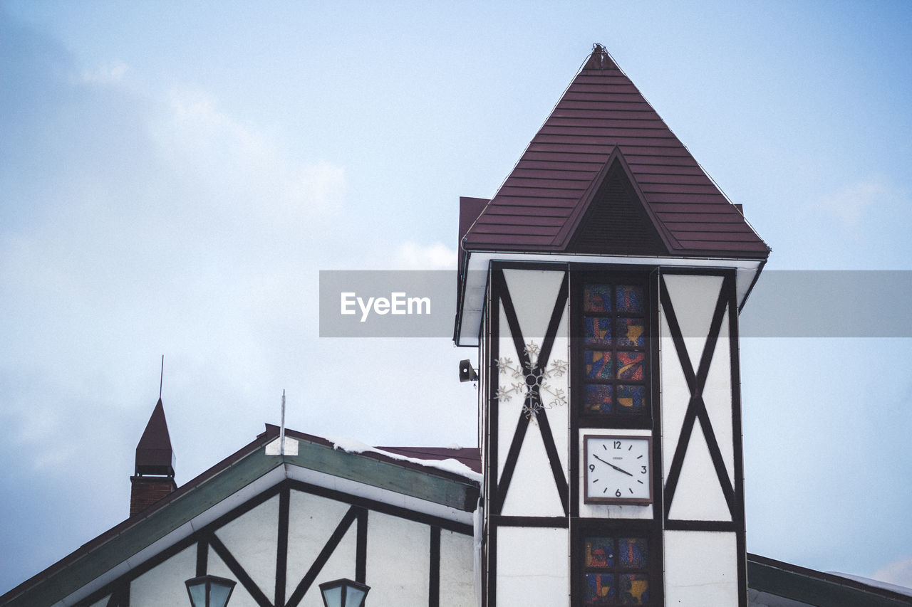 LOW ANGLE VIEW OF BUILDING AND CROSS AGAINST SKY