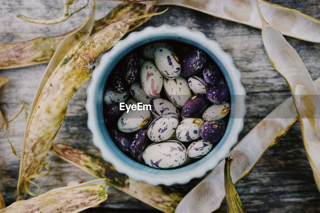 Close-up of beans in container on wooden table