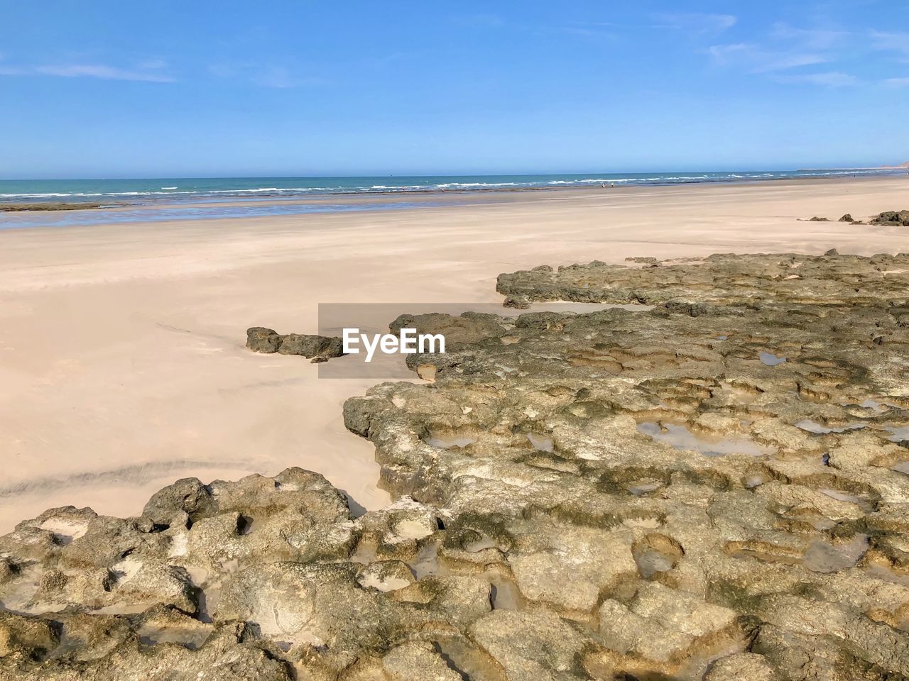 Scenic view of rocks on beach against sky