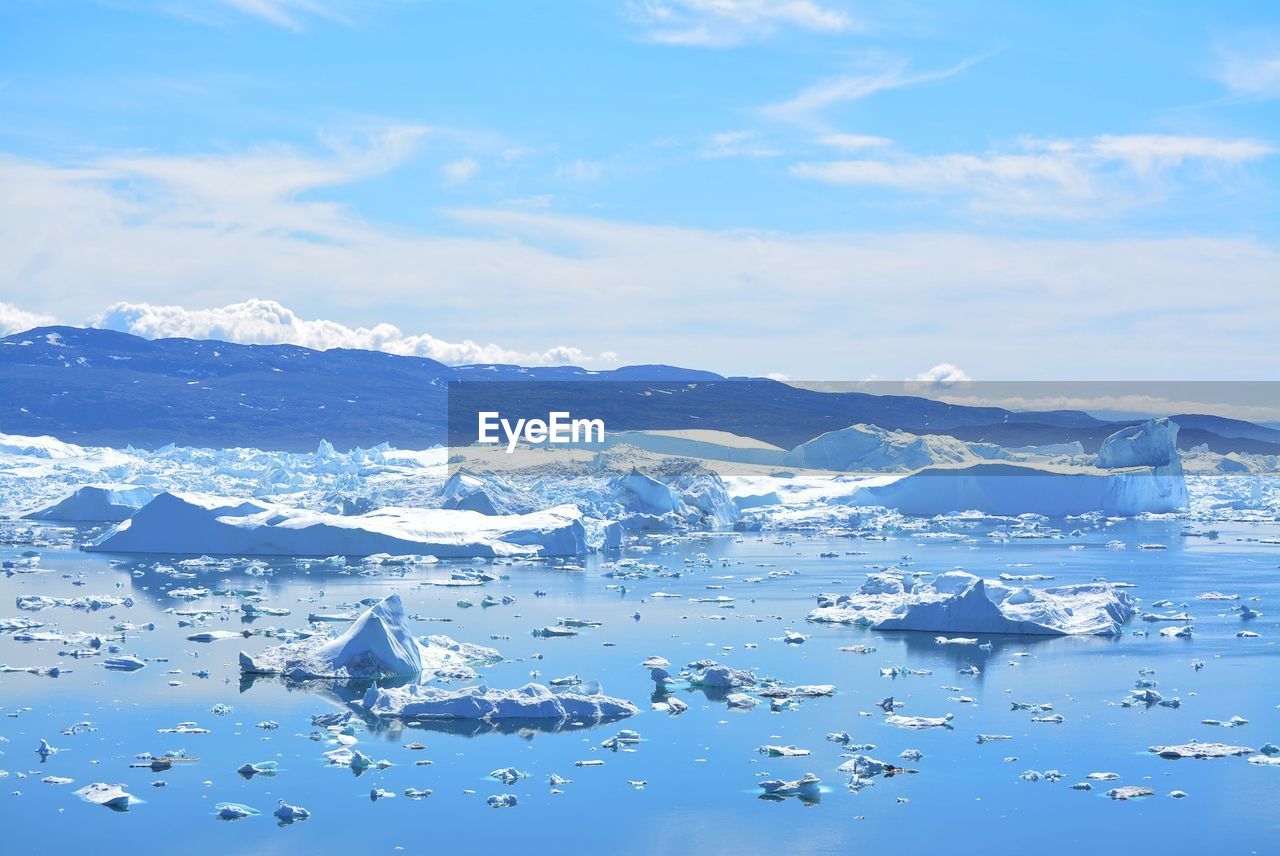 AERIAL VIEW OF SEA AND SNOWCAPPED MOUNTAINS AGAINST SKY