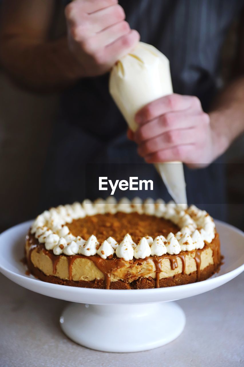 MIDSECTION OF PERSON HOLDING CAKE