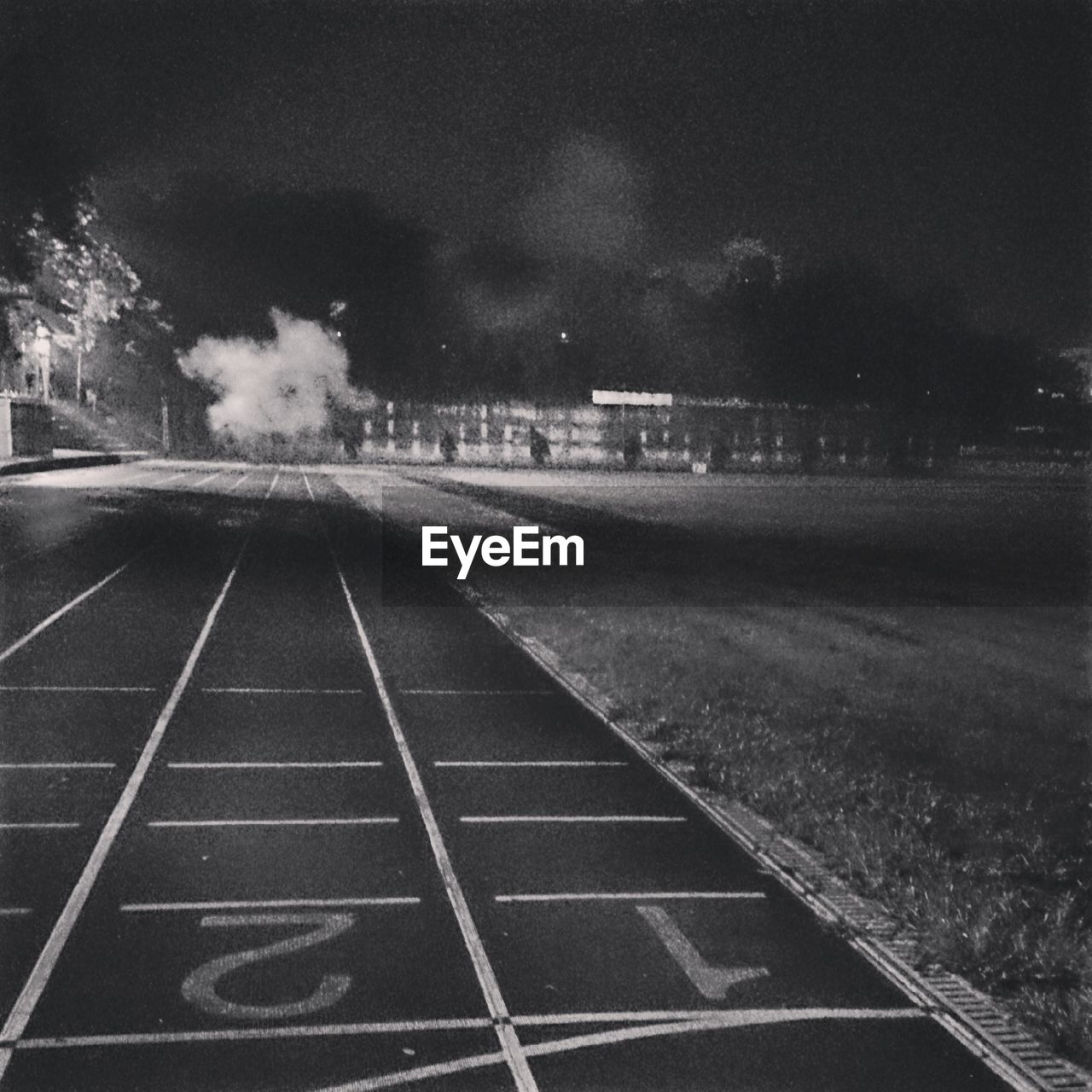 RAILROAD TRACKS ON ROAD AT NIGHT