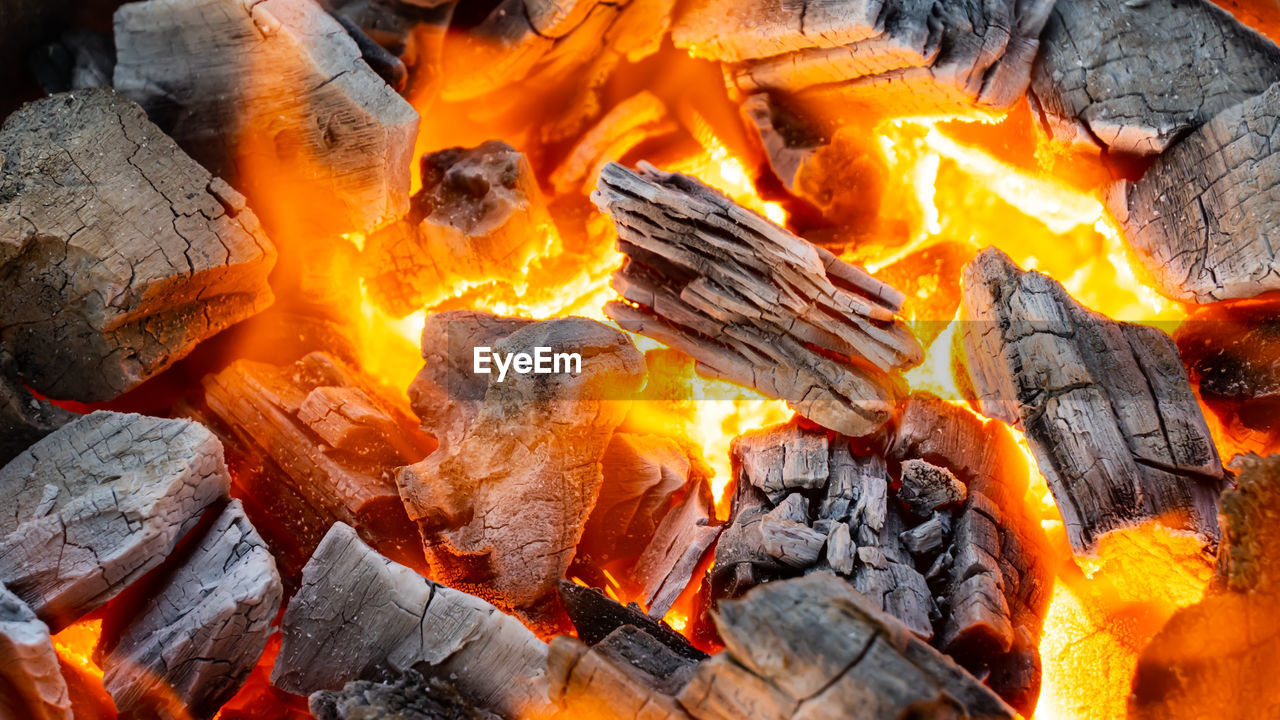 CLOSE-UP OF BONFIRE ON WOODEN LOGS