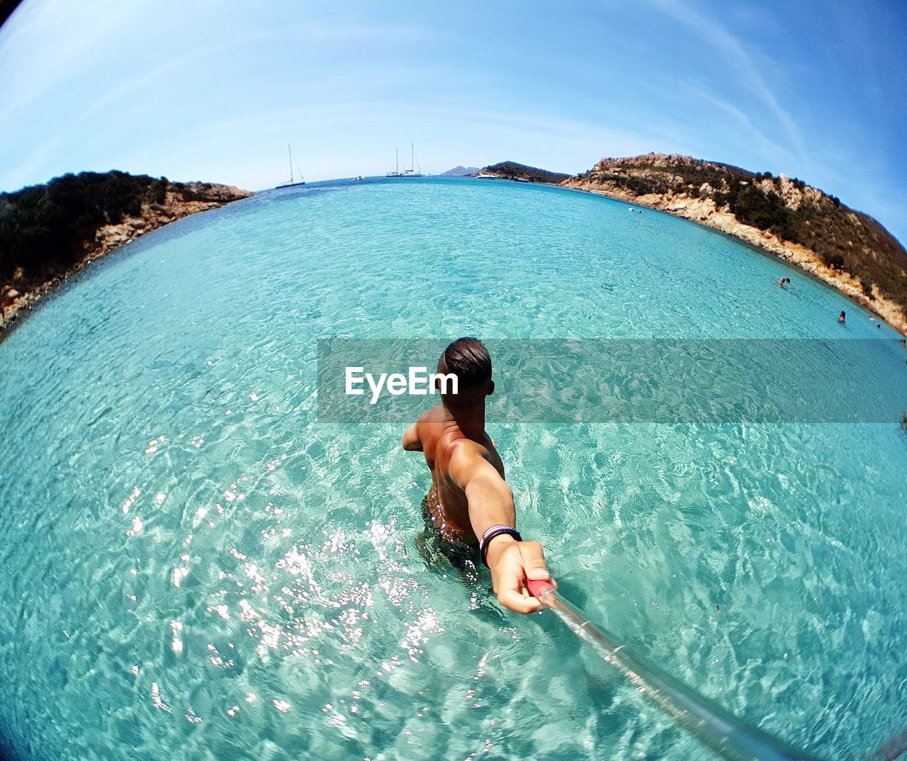 REAR VIEW OF SHIRTLESS MAN IN SEA