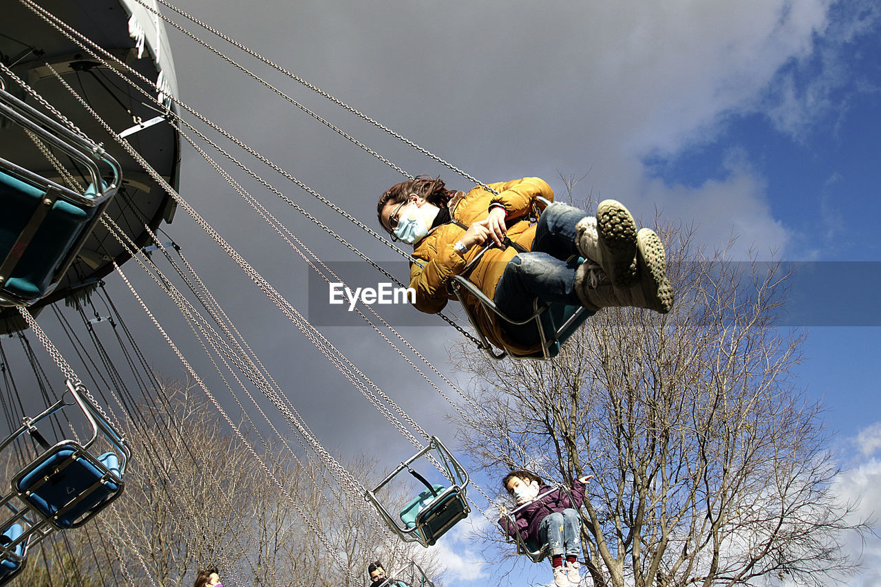 Low angle view of chain swing ride against sky