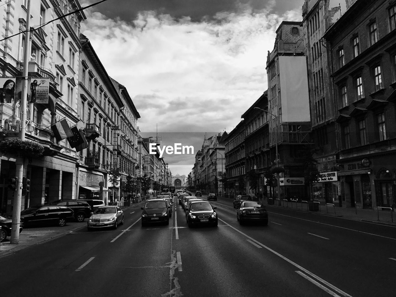 Cars on street in city against sky