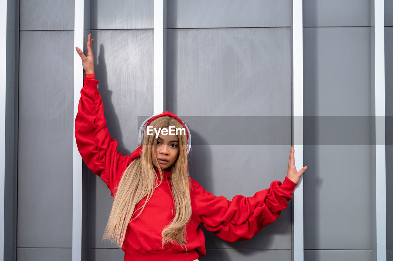 Cheerful african american woman with long blonde hair wearing sportswear and wearing headphones