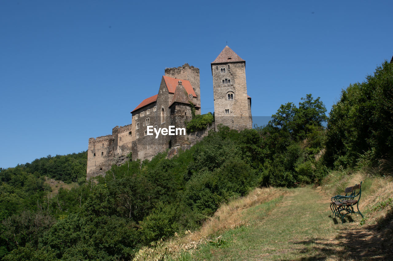 low angle view of old ruins against clear blue sky