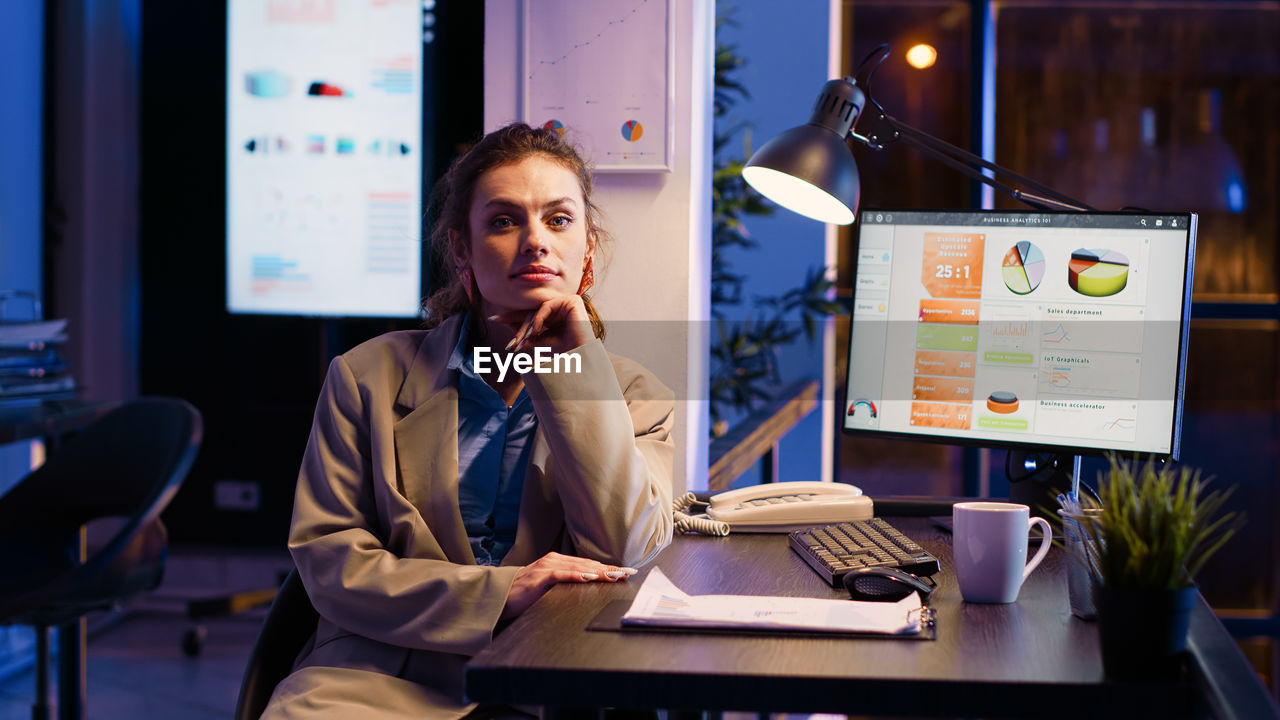 young woman using laptop while sitting on table