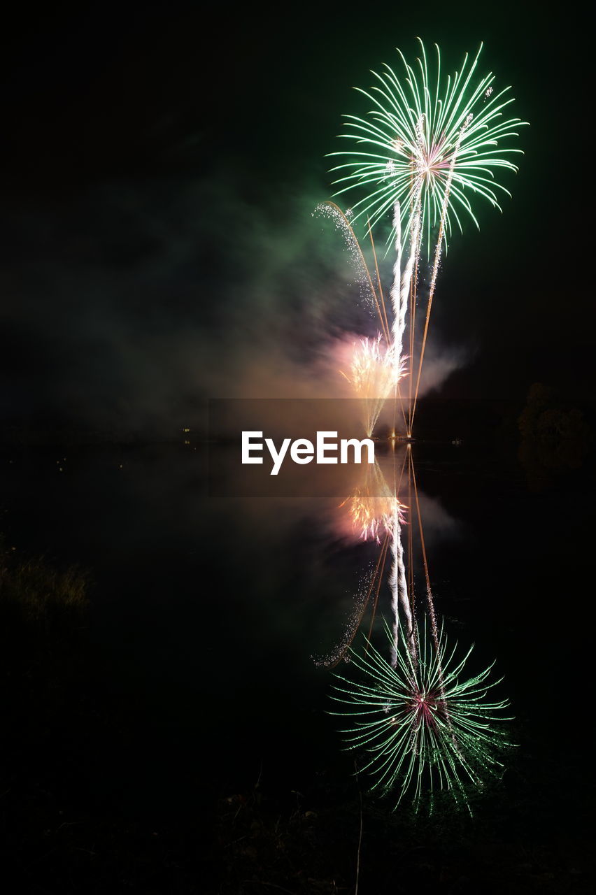 Fireworks reflecting on lake at night