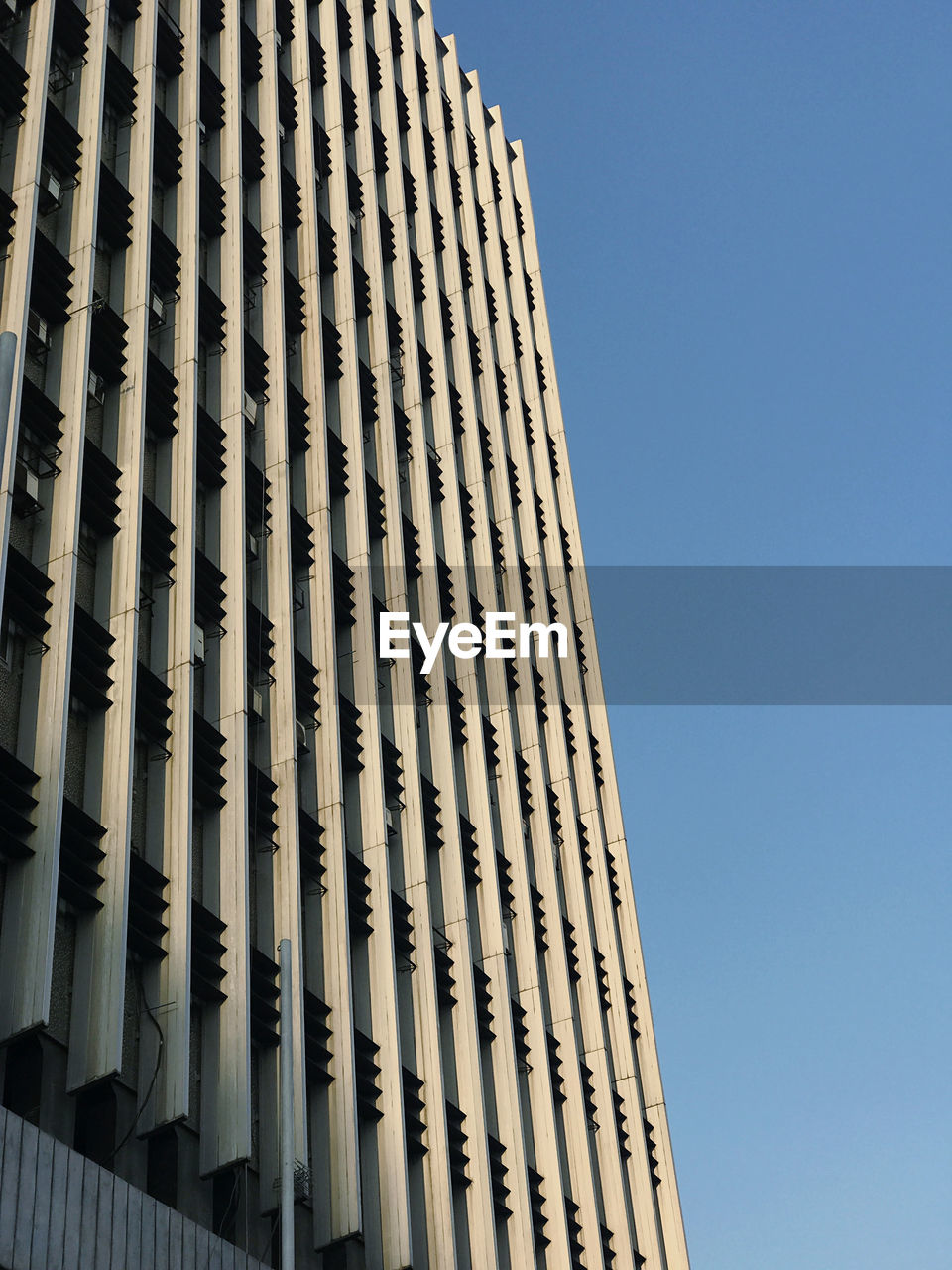 Low angle view of modern building against clear blue sky