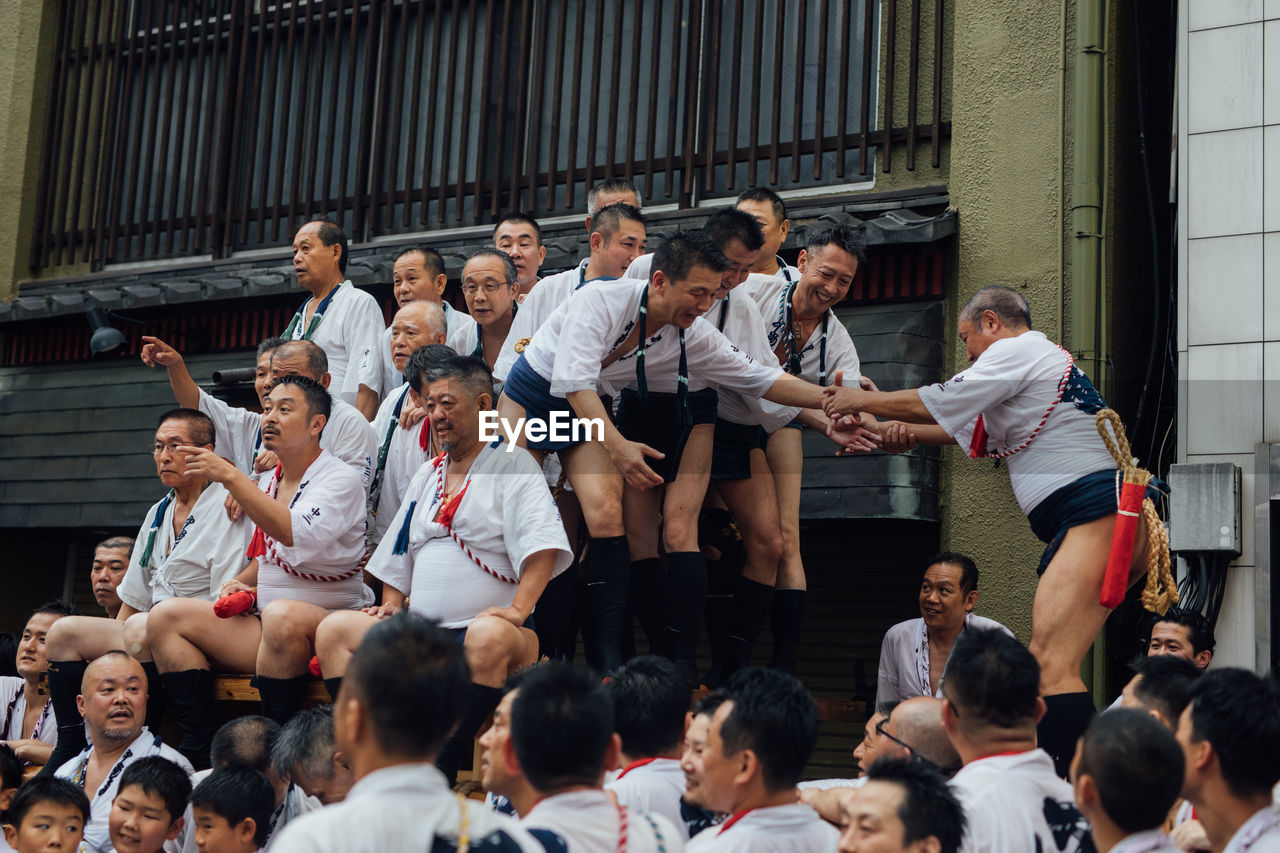 GROUP OF PEOPLE STANDING IN FRONT OF AN BUILDING