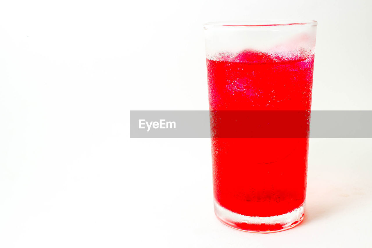 Close-up of red glass against white background