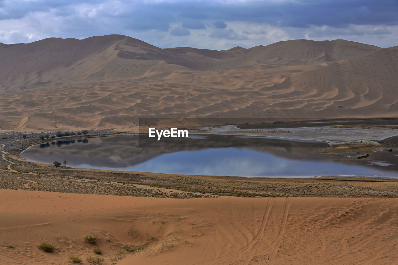 1097 yindeertu-yinderitu lake-badain jaran desert-dark water-cloudy sky-megadunes. nei mongol-china.