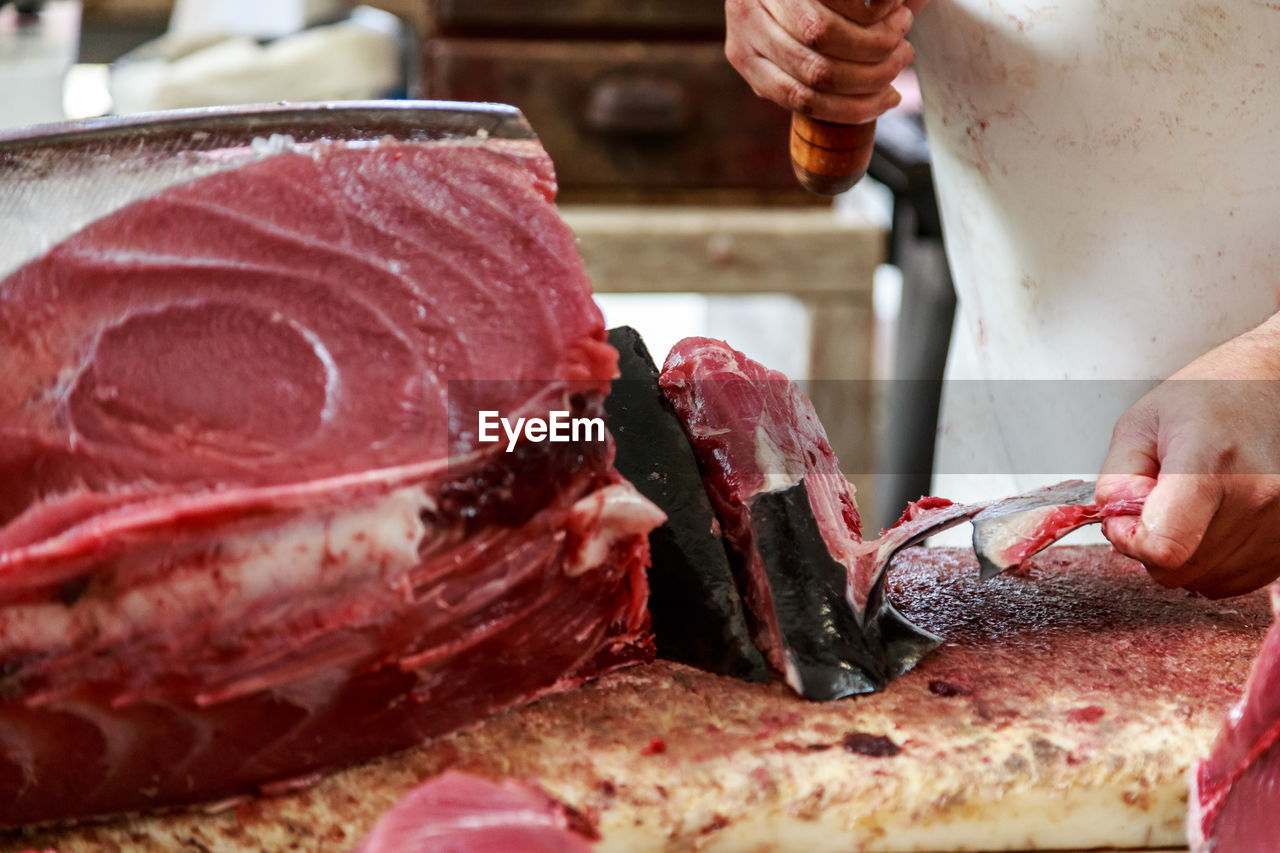 Close-up of man cutting tuna