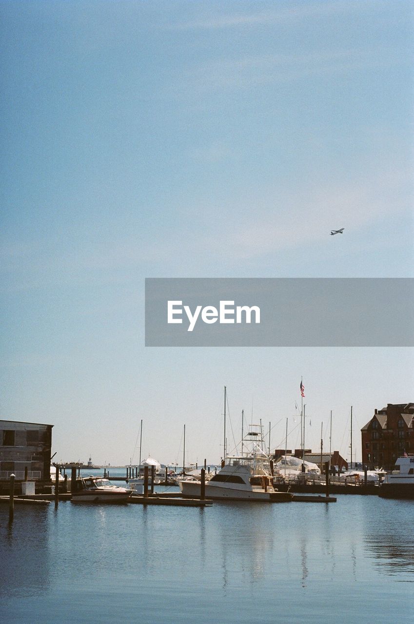 Boats moored in lake against clear sky