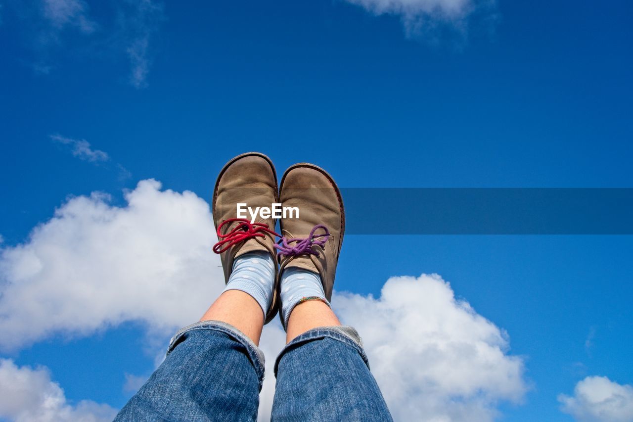 Low section of woman against blue sky