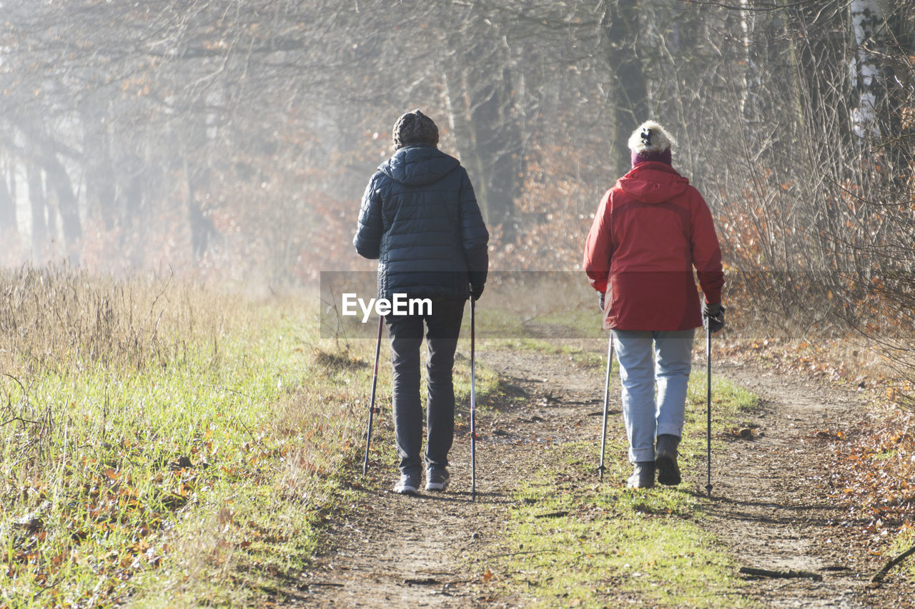 Rear view of two women practicing nordic walking