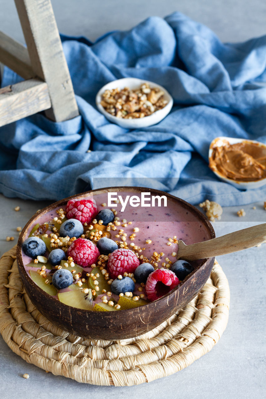 Top view of nutritious breakfast bowl with berries and yogurt served on table in morning