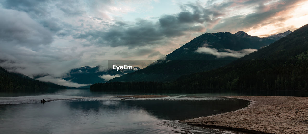 scenic view of lake by mountains against sky