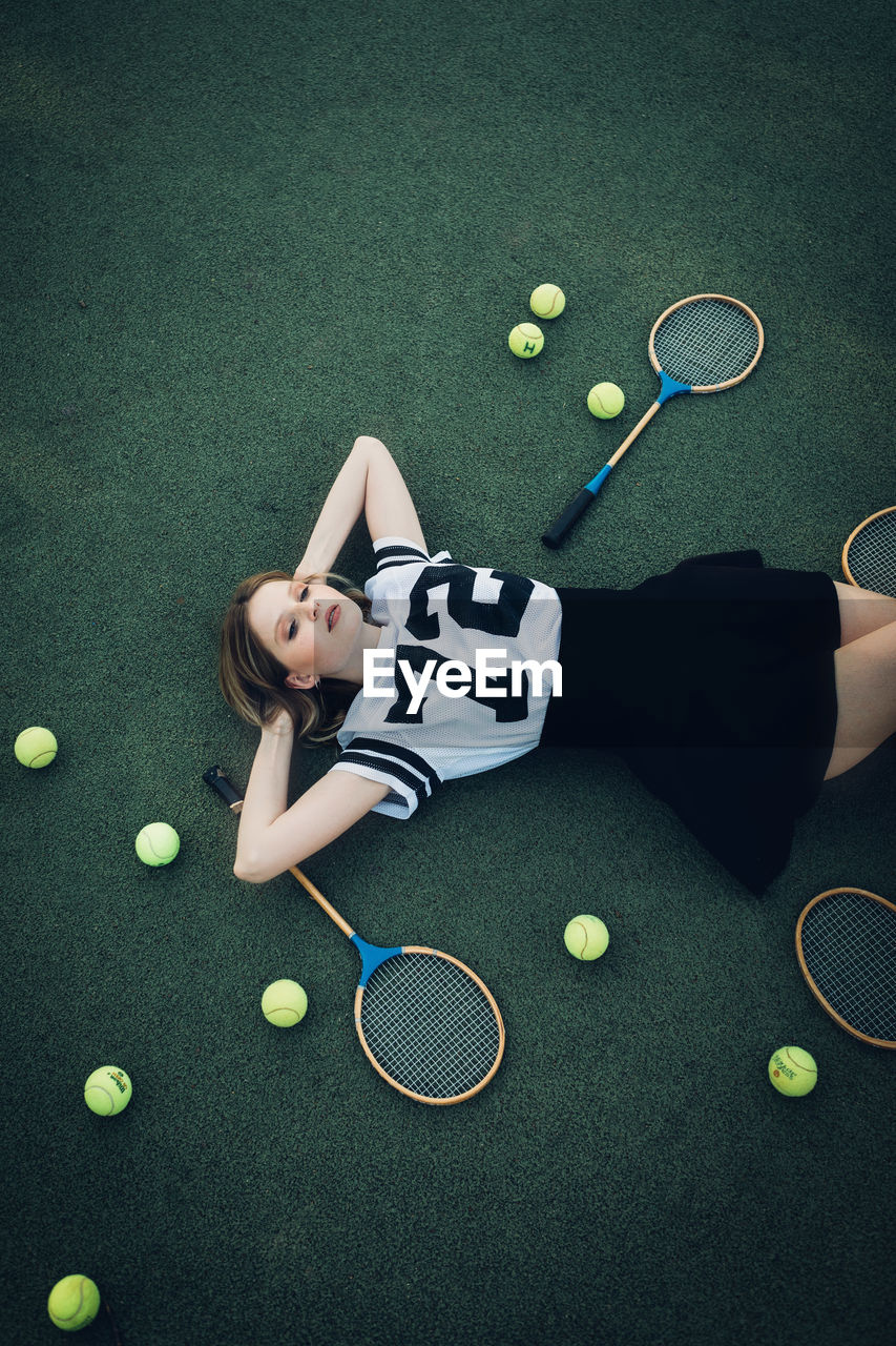 High angle view of tired young woman lying on court